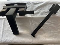 Matte black faucet and bar side by side on white cloth background for size and condition display.