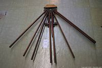 Drying rack fully extended with multiple wooden rods fanned out on a tiled floor.