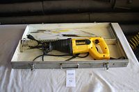 DeWalt DW303 saw and blades inside metal carrying case on white cloth surface