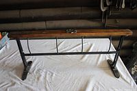 Full view of large paper dispenser showing wooden top, metal wire dividers, and cast iron base.
