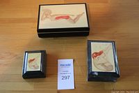 Three-piece lot with Vargas girl paperweight and two decorative boxes on a wood surface.