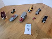 Full lot overview showing all eight vintage toy vehicles arranged on wooden surface.
