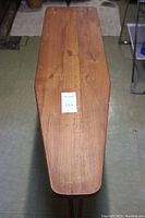 Top view showing the wooden planked surface of the ironing board with a sticker on it.