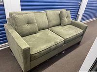 Front view of olive green Barrymore loveseat showing two seat cushions and two button-tufted back pillows