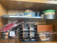 Shelf with packages of Duracell batteries in different sizes (AA, C, 9V), wooden box, and packaged accessories