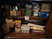 Shelves containing various candles, LED candles, tealight candles, and mosaic and metallic candle holders