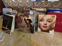 Front view of multiple coffee table books arranged in two rows showing variety of titles.