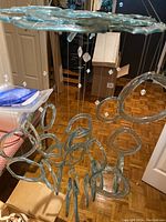 Glass sun catcher mobile hanging with multiple clear glass rings suspended from a circular flat glass top and small clear beads on strings.