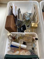 Overhead shot showing multiple perfume bottles, including star-shaped bottles and a brown case, along with some small containers and a lipstick.