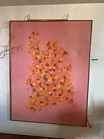 Full view of painting in gold frame hung on wall with art light above