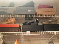 Multiple shelves of women's shoes size 9 including brand boxes and various styles.