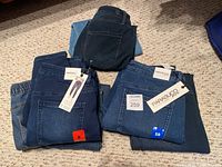 Four pairs of Parasouco denim jeans folded on carpet, showing size 8 and 10 labels