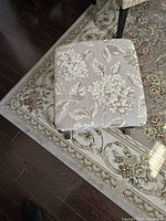 Top view of the upholstered floral fabric seat on the wood stool