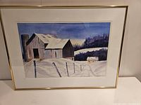 Full view of the framed watercolor painting showing the farm scene with barn, snowy ground, fences, and trees under blue sky.