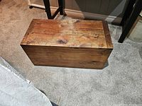 Top view of antique solid wood toy trunk showing natural wood grain and aged surface.
