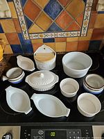 Full overview of the 11 piece bakeware collection showing various dishes, ramekins, salt container and cups.