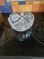 Crystal fruit bowl placed on stovetop showing side view and overall shape.