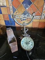 Steampunk-style glass instrument with metal frame and antique clock with compass on base, clock face dated 1903 Columbia Clock Co.