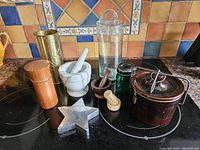Overview of the 9 miscellaneous kitchen items on a stove top with colorful tile backsplash, showing all items arranged together.