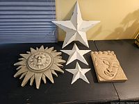 Full display of five celestial wall pieces including sun face, two stars, moon face, and smaller sun plaque