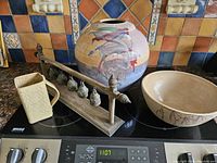 Overview of entire collection including the large vase, bowl, pitcher, and set of religious bells on wooden stand.