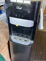 Front view of black Master Chef bottom-load water dispenser showing dispenser panel with indicator lights and drip tray.