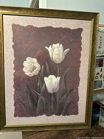 Framed print showing three white tulips on a reddish-brown textured background with a gold-tone frame.