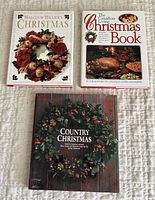 Three Christmas-themed hardcover books arranged flat with distinct decorative covers visible