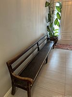 Full length view of bench against wall showing overall form and finish wear