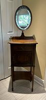 Full view of shaving stand showing mirror, top surface, drawer, cabinet and legs