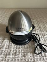 Front view of assembled Cuisinart egg cooker showing stainless steel dome with brand and label.