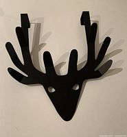 Front view of black metal reindeer shaped overdoor hook showing hooks for hanging over door and antler design.
