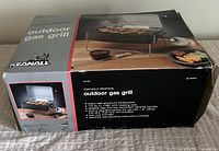 Front and top of the original box showing image of grill with lid open and food cooking, product details and brand name Keanall