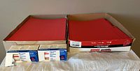 Red file folders stacked and boxes of labels displayed