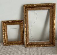Two vintage gilded frames side by side showing size comparison and gold ornate details.
