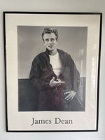 Frontal view of the framed poster showing James Dean sitting casually in dark jacket and white T-shirt.