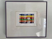 Framed serigraph 'Twong's Crayons' hanging on wall