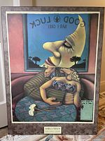 Full view of framed 'Phases of the Moon' artwork showing two stylized anthropomorphic figures with a large moon face in the background, trees and window visible.