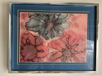 Framed print showing stylized poppies in red and gray, double matted and framed in a metallic frame.