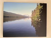 Full view of stretched canvas showing the serene mountain and lake scene with trees along the water edge.