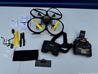 Complete set showing UDI RC FPV drone, controller, goggles, manuals, spare propellers, accessories spread on a white surface.