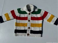 Front view of the multicolor striped baby sweater laid flat showing full sleeve and button detail.