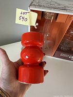 Close-up of vibrant red candleholder held in hand showing geometric shape.