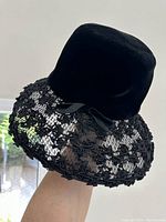 Side and angled views of the vintage Ellen Faith hat showing the black velvet crown, intricate lace brim with embroidery, and small velvet bow detail.