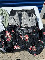Photo of assorted women's clothing including floral blouse, grey knit cardigan, dark jeans.