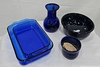 All items arranged together on white background showing the full set of cobalt blue dishes and vase.