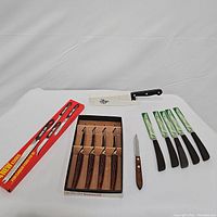 Overview of all cutlery items including boxed vintage set of 4 knives, 5 Quikut knives with green sleeves, Pampered Chef carving knife, and small wooden handle knife.