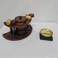 Photo of the entire vintage smoke lounge set showing pipe holder with humidor and corncob pipes alongside a vintage safety bean bag ashtray.