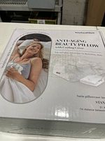 Box cover showing woman using the anti-aging beauty pillow with cooling cover.