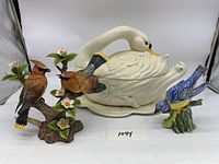 Photo showing the Lenox ceramic swan tureen, two cardinal bird figurines on a tree branch, and a Stangl blue bird figurine.